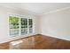 Light-filled living room with hardwood floors and a large window overlooking the yard at 809 Green Passage Ln, Apex, NC 27502