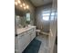 Well-lit bathroom with white vanity, modern fixtures, gray tile floor, and a convenient toilet at 820 Christian Light Rd, Fuquay Varina, NC 27526
