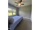 Bright bedroom with plush carpet, a large window offering a scenic view, and a ceiling fan at 820 Christian Light Rd, Fuquay Varina, NC 27526