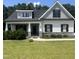 Charming home showcasing gray siding, black shutters, manicured lawn, and inviting front porch with stone accents at 820 Christian Light Rd, Fuquay Varina, NC 27526