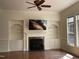 The living room has a fireplace, built-in shelves, hardwood floors, a ceiling fan, and large windows at 8228 Clarks Branch Dr, Raleigh, NC 27613