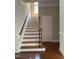 Staircase leading to the upper level, featuring wood and white trim at 8228 Clarks Branch Dr, Raleigh, NC 27613