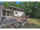 Backyard featuring a wooden deck with unique bridge and stone paver steps leading to a grassy lawn at 8510 Dunlee Falls Rd, Raleigh, NC 27613