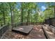 Backyard featuring a wooden deck with hot tub and built-in bench, surrounded by lush trees at 8510 Dunlee Falls Rd, Raleigh, NC 27613