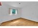 A bright bedroom featuring hardwood floors, a window with natural light, and neutral-colored walls at 8510 Dunlee Falls Rd, Raleigh, NC 27613