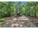 Gravel driveway winding through mature trees leading to the home at 8510 Dunlee Falls Rd, Raleigh, NC 27613