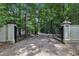 Gated home entrance with stone columns and mature trees leading to the estate at 8510 Dunlee Falls Rd, Raleigh, NC 27613