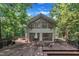 Modern home exterior featuring a spacious wooden deck and large windows, surrounded by lush trees at 8510 Dunlee Falls Rd, Raleigh, NC 27613