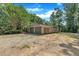 Detached two-car garage featuring a gravel driveway and surrounded by mature trees at 8510 Dunlee Falls Rd, Raleigh, NC 27613