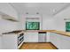 Bright kitchen with white cabinets, light countertops, and a window with a view of the lush greenery at 8510 Dunlee Falls Rd, Raleigh, NC 27613