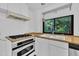 Well-lit kitchen featuring white cabinets, modern appliances, and a bright window with outdoor scenery at 8510 Dunlee Falls Rd, Raleigh, NC 27613