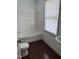 Bright bathroom featuring a tub and shower combination and a large window at 903 New Bern Ave, Raleigh, NC 27601