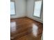 Bedroom featuring hardwood floors and natural light from two windows at 903 New Bern Ave, Raleigh, NC 27601