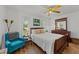 Bedroom with neutral walls, wood laminate floors, a ceiling fan, a bed, two windows, and vintage decor at 918 Circle Dr, Angier, NC 27501