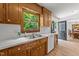 Traditional kitchen with wood cabinets, stainless sink, white counters, and a window overlooking the greenery at 918 Circle Dr, Angier, NC 27501
