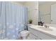 Bright bathroom features a vanity with a white sink and a shower with a blue curtain at 109 Grey Elm Trl, Durham, NC 27713