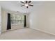Neutral bedroom features a ceiling fan, neutral carpet, and a large window at 109 Grey Elm Trl, Durham, NC 27713