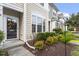 Charming townhouse exterior featuring manicured landscaping, lush bushes and covered entrance at 109 Grey Elm Trl, Durham, NC 27713