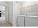 Efficient laundry room featuring a washer, dryer, and storage shelving above for organization at 109 Grey Elm Trl, Durham, NC 27713