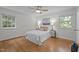 Bright bedroom with hardwood floors, two windows, ceiling fan, and a comfortable bed at 111 Lattimore Ln, Durham, NC 27713