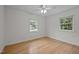 Bright bedroom with wood floors featuring two windows and natural light at 111 Lattimore Ln, Durham, NC 27713