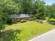 Charming single-story brick home with a well-manicured lawn and mature trees at 111 Lattimore Ln, Durham, NC 27713