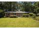 Charming brick home with a well-manicured lawn, mature trees, and lush landscaping at 111 Lattimore Ln, Durham, NC 27713