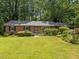 Charming brick home with a well-manicured lawn, mature trees, and lush landscaping at 111 Lattimore Ln, Durham, NC 27713