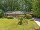 Charming brick home with green lawn, mature landscaping, and driveway at 111 Lattimore Ln, Durham, NC 27713