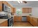 Cozy kitchen featuring wood cabinets, stainless steel appliances, and a window providing natural light at 111 Lattimore Ln, Durham, NC 27713