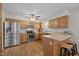 Spacious kitchen with stainless steel appliances, wood cabinets, and a breakfast bar with seating at 111 Lattimore Ln, Durham, NC 27713