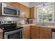 Bright kitchen featuring a stainless steel oven, microwave, and a window providing natural light at 111 Lattimore Ln, Durham, NC 27713