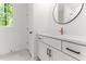 Bathroom featuring a white vanity with dark hardware, round mirror and tiled floor at 121 Quarterhorse Dr, Louisburg, NC 27549