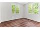 Bright bedroom with hardwood floors and natural light from two windows at 121 Quarterhorse Dr, Louisburg, NC 27549