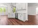 View of kitchen with stainless steel dishwasher, white cabinets, dark hardware and wood flooring at 121 Quarterhorse Dr, Louisburg, NC 27549
