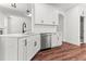 Modern kitchen with white cabinets, stainless steel dishwasher, dark hardware and wood flooring at 121 Quarterhorse Dr, Louisburg, NC 27549