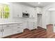 Bright kitchen features white cabinets, dark hardware, a microwave, and wood flooring at 121 Quarterhorse Dr, Louisburg, NC 27549