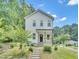 Charming two-story white home featuring a welcoming front porch and landscaped front yard at 1213 Grant St, Durham, NC 27701