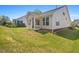 Large backyard with well-maintained lawn, covered porch, and mature trees offering privacy and shade at 136 Durie Way, Garner, NC 27529