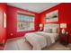 Bedroom featuring red walls, a neutral bed, blinds, and a decorative painting at 136 Durie Way, Garner, NC 27529