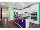 Bright kitchen with stainless steel appliances, white cabinets, and a central island with a breakfast bar at 136 Durie Way, Garner, NC 27529