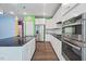 Modern kitchen with white cabinets, stainless steel appliances, and a dark kitchen island at 136 Durie Way, Garner, NC 27529