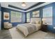 Spacious bedroom with a tray ceiling, recessed lighting, a large window, and calming blue walls at 136 Durie Way, Garner, NC 27529