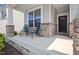 Inviting front porch with stone accents and space for relaxing with chairs at 136 Durie Way, Garner, NC 27529