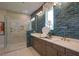 Modern bathroom featuring blue tiled walls, glass shower, double sinks, and dark stained cabinets at 16 Calming Pl Pl, Fuquay Varina, NC 27526