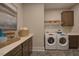 Convenient laundry room featuring cabinets, shelving, and modern washer and dryer at 16 Calming Pl Pl, Fuquay Varina, NC 27526