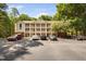 View of a three-story condo building with white balconies and ample parking surrounded by mature trees at 1851 Trailwood Heights Ln # 201, Raleigh, NC 27603