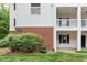 Exterior view of a two-story condo building with white siding, brick accents, and well-kept landscaping at 1851 Trailwood Heights Ln # 201, Raleigh, NC 27603
