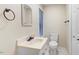 Bathroom featuring a mirror, sink, toilet, storage closet, and a window for natural light at 201 Shady Lane Dr, Smithfield, NC 27577