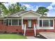 Close-up of a well-maintained brick home showcasing the welcoming front porch and detailed trim at 201 Shady Lane Dr, Smithfield, NC 27577